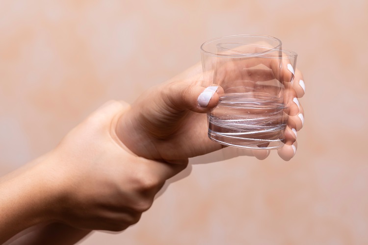 a woman holding a glass of water in her hand