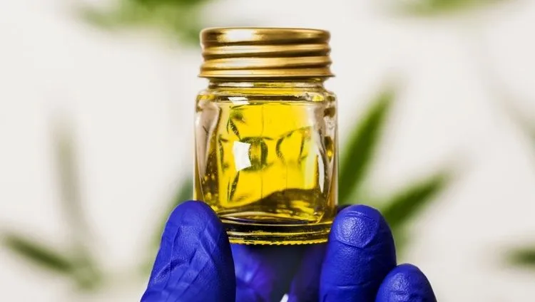 Detail of a glass bottle containing CBD oil used as a supplement to manage the symptoms of bipolar disorder