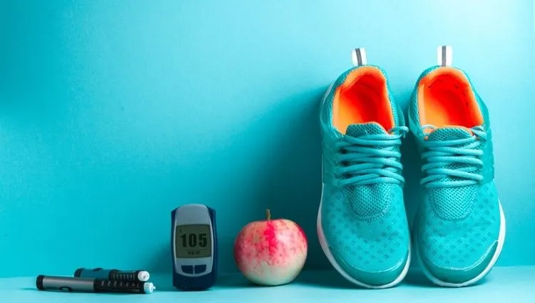 Glucometer, insulin pen, apple, and athletic shoes – healthy lifestyle with diabetes