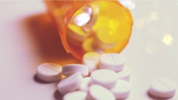 Spildte hvide tabletter fra en medicinflaske – illustration af benzodiazepinafhængighed