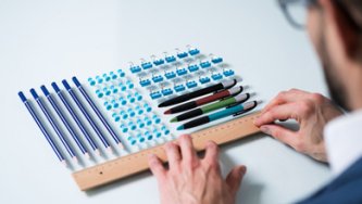 Oseba, ki natančno poravnava predmete v natančne vrste – vizualna metafora obsesivno-kompulzivne motnje (OCD).