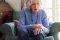 Elderly woman sitting in an armchair suffering from Parkinson’s disease