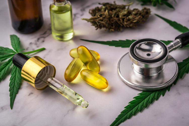 CBD oil, capsules, and cannabis products next to a stethoscope – an illustration of the possible use of CBD for mental health issues such as OCD.