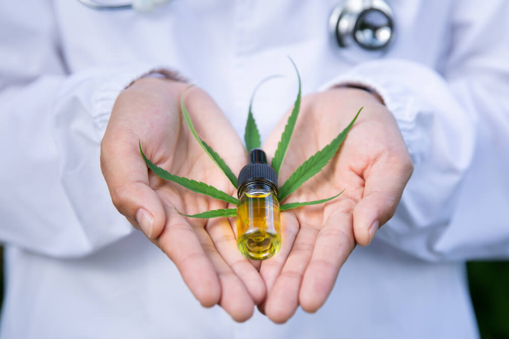 Hands holding CBD oil, which can have side effects
