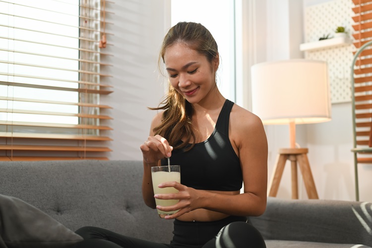 A woman mixes herself a collagen drink, a great Christmas gift tip for women