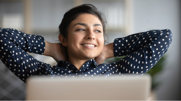 Smiling woman sitting on a chair, looking relaxed and content – visual representation of CBD relieving nerve pain