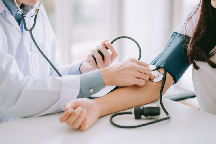 The doctor checks whether the patient has hypertension (high blood pressure)