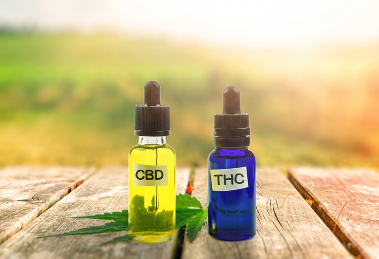 A yellow glass vial labeled CBD and a blue glass vial labeled THC