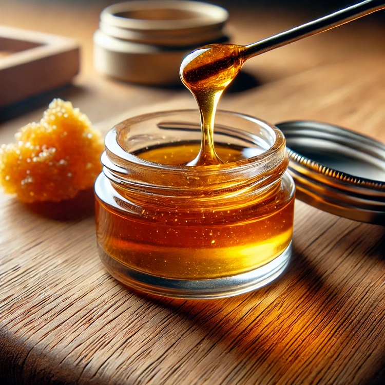 A special tool scoops the golden-coloured liquid live resin from the container
