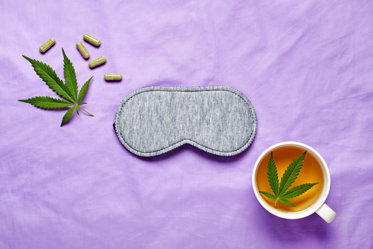 "CBD products, a sleep mask, and herbal tea with a cannabis leaf — symbolizing the connection between cannabinoids and sleep or dreaming."
