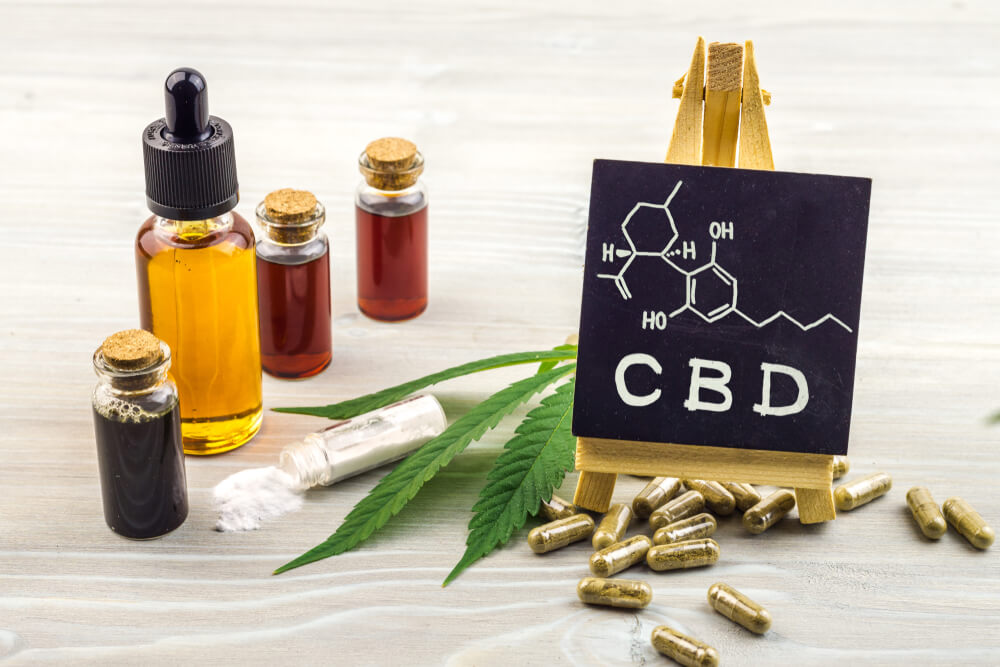 CBD oils, extracts and capsules, chalk board with inscription: CBD and molecular formula