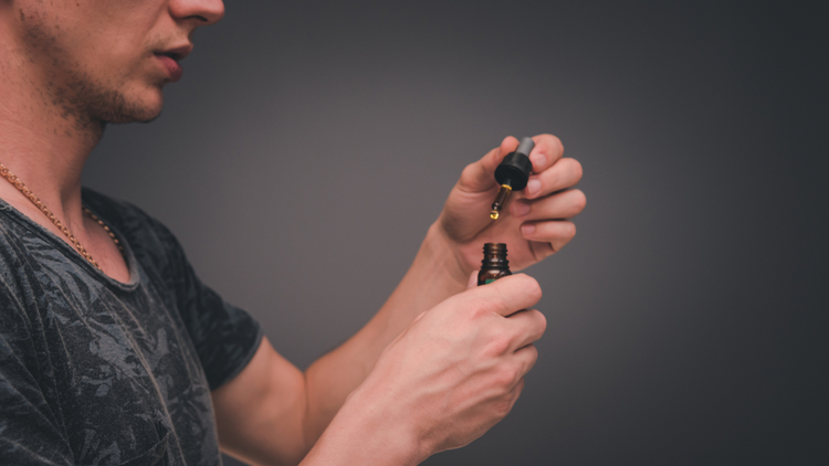 A man holding a bottle of CBD oil
