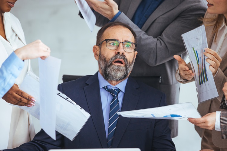 The concept of multitasking. The overworked entrepreneur sitting at a laptop overloaded with multitasking in the modern office